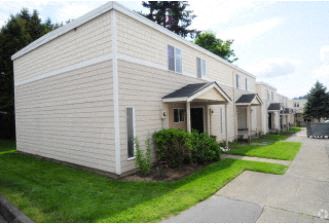 a row of white mobile homes on a street